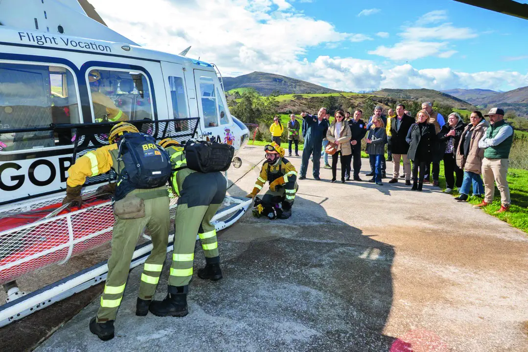 Miembros de la Brigada de Refuerzo en Incendios Forestales realizando una demostraci&oacute;n junto al helic&oacute;ptero. / Alerta