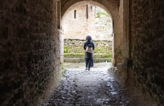 Una turista paseando por Santillana del Mar en un d&iacute;a de lluvia. / A.S.