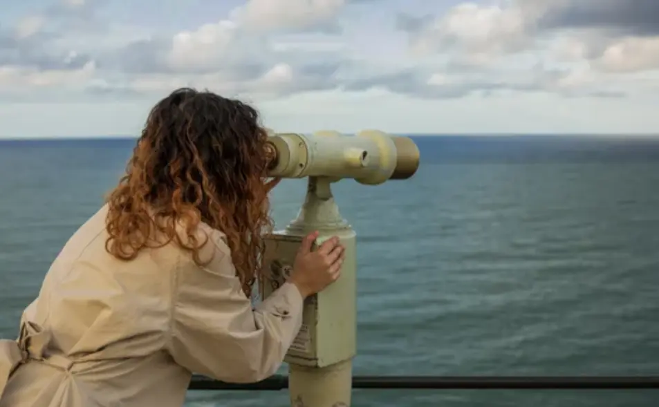Turista usando binoculares en el Palacio de la Magdalena con vistas a la bah&iacute;a de Santander.