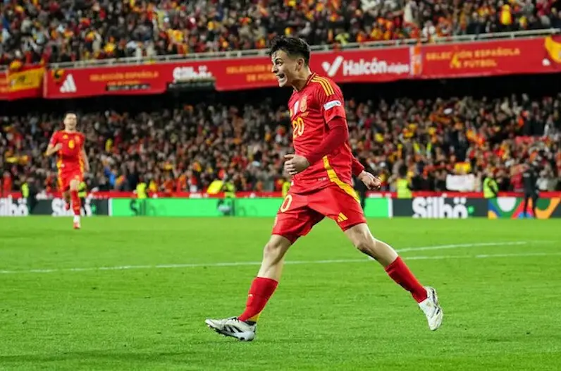 La imagen muestraa Pedri , futbolista de la selecci&oacute;n espa&ntilde;ola , celebrando efusivamentedurante un partido . Luce la camiseta roja de Espa&ntilde;acon el dorsal n&uacute;mero 20 , y su expresi&oacute;n refleja puraemoci&oacute;n, probablemente tras marcar el penalti decisivo en la clasificaci&oacute;n de Espa&ntilde;a a la Final Four de la UEFA Nations League frente a Pa&iacute;ses Bajos en Mestalla.