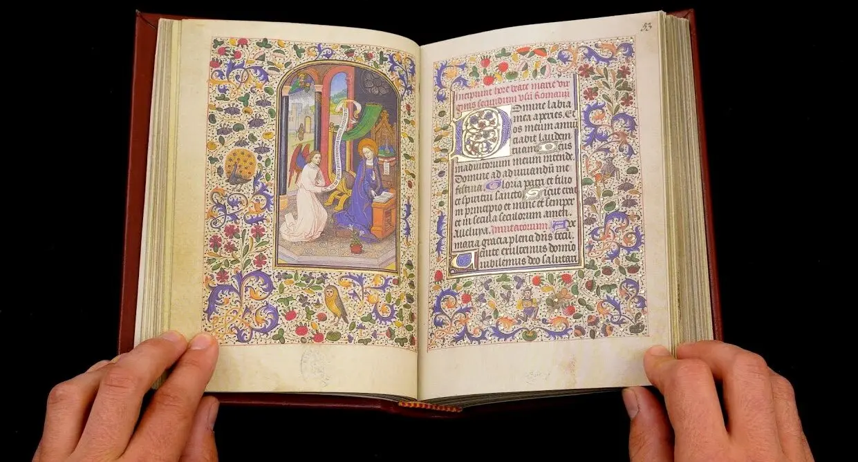 Miniatura: Coronaci&oacute;n de la Virgen. Circa 1468. Manuscrito iluminado sobre pergamino atribuido al artista flamenco Willem Vrelant. Encargado en Flandes y enviado a Espa&ntilde;a como regalo diplom&aacute;tico, el c&oacute;dice acab&oacute; en manos de Leonor de la Vega, hermana del poeta Garcilaso de la Vega, de quien tom&oacute; su nombre. Conservado actualmente en la Biblioteca Nacional de Espa&ntilde;a (Vitr.24-2), este libro es una joya del arte g&oacute;tico y fue seleccionado en 2016 como una de las 15 obras m&aacute;s importantes de Espa&ntilde;a para el proyecto Europeana 280.
