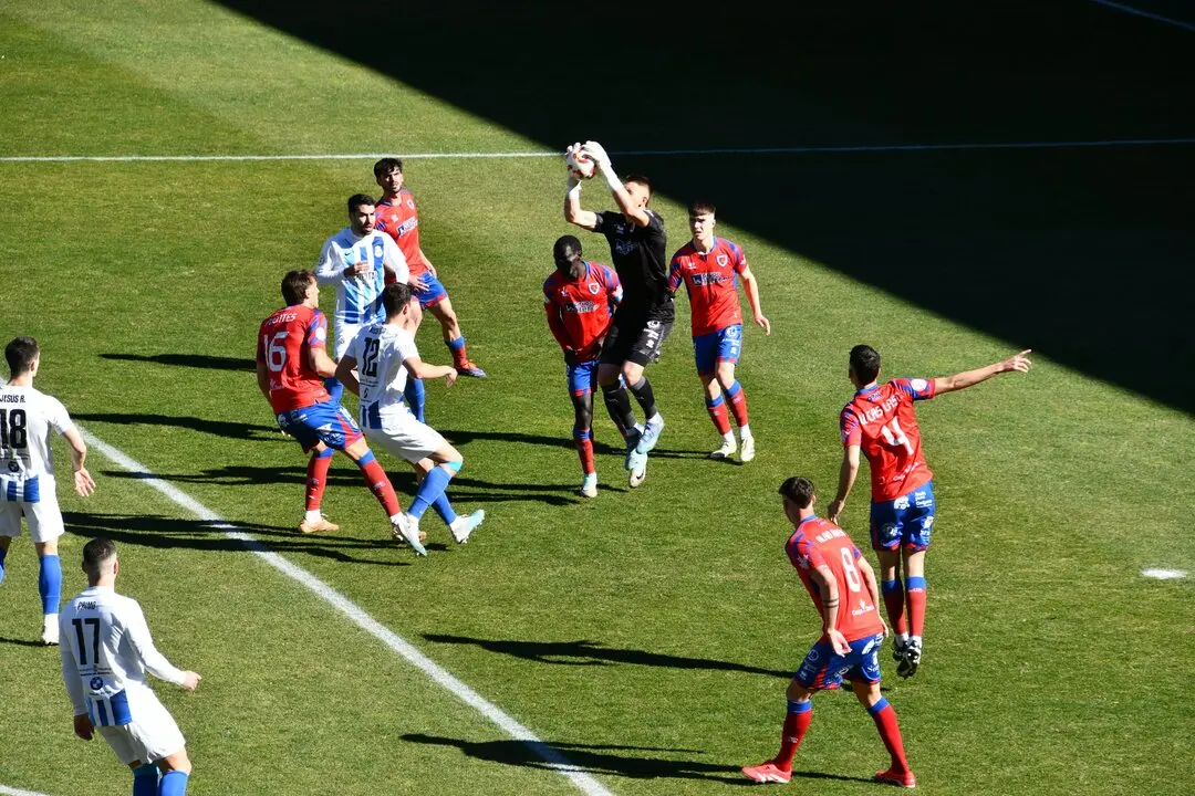 El portero del Numancia despeja un bal&oacute;n a&eacute;reo ante varios jugadores de la Gimn&aacute;stica durante un partido que sentenci&oacute; a&uacute;n m&aacute;s el futuro del conjunto torrelaveguense. / X