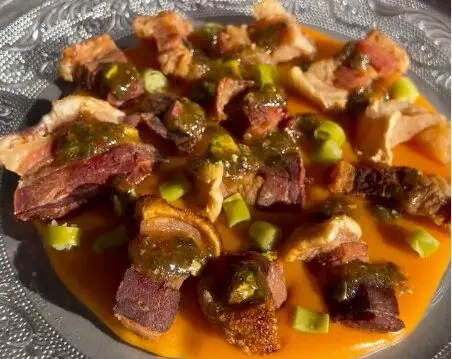 Torreznos sobre base de espuma de patata revolcona y chimichurri de pistachos, uno de los platos del restaurante. / B.G.