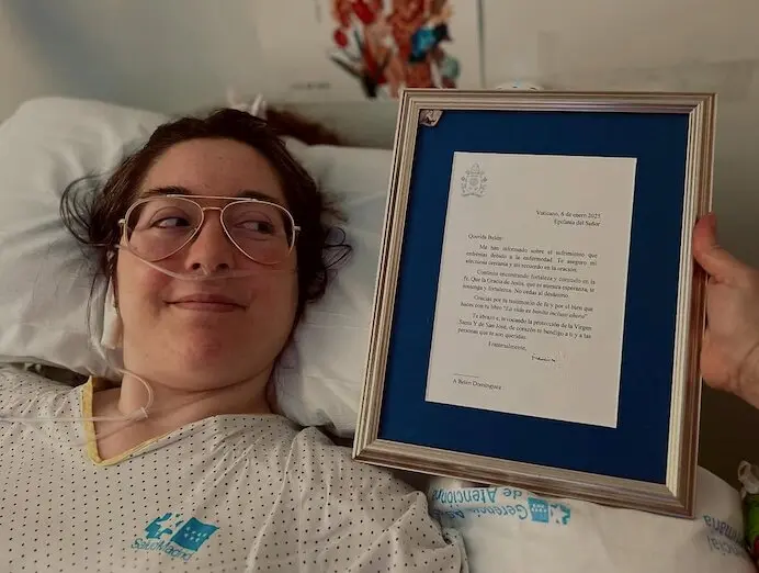 La joven durante su ingreso hospitalario junto a una carta del Papa Francisco. / belendominguezb