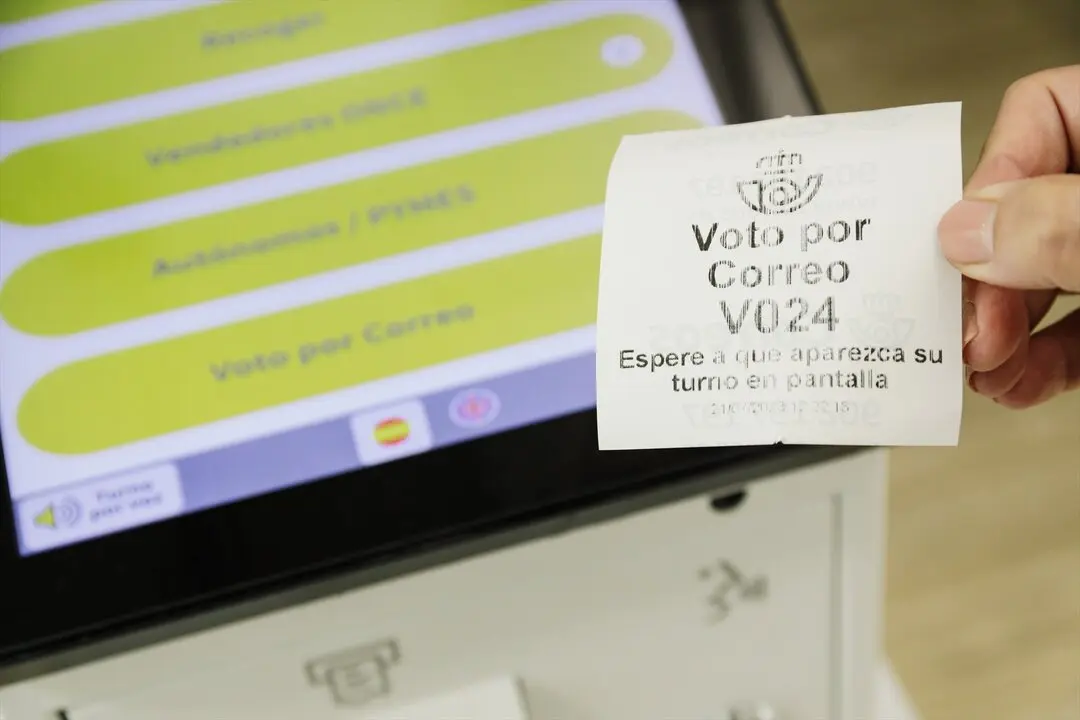 Un ticket de turno de voto por correo en la oficina de Correos. / Carlos Luj&aacute;n