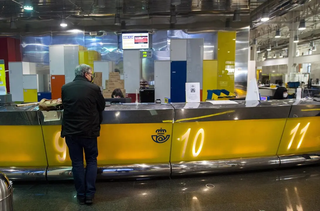 Un cliente es atendiendo en la Oficina de Correos de Cibeles, en Madrid. / Alberto Ortega