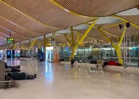 Varias personas durmiendo en Barajas. / X