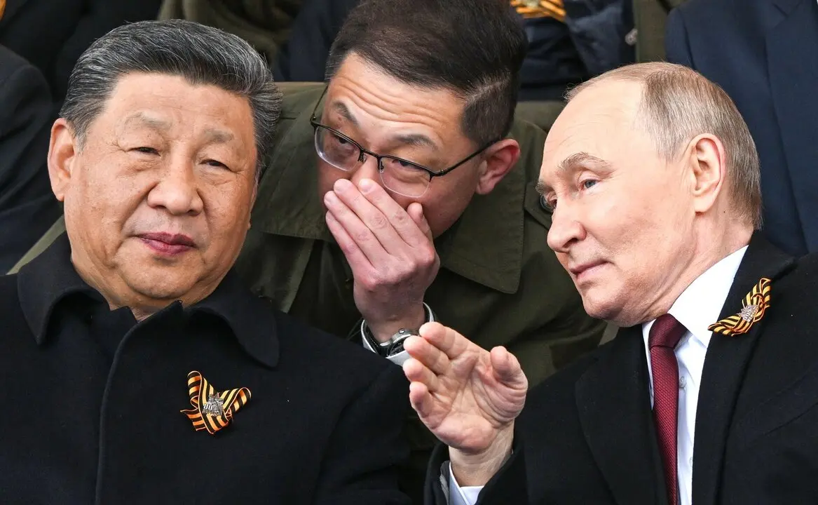El presidente ruso, Vlad&iacute;mir Putin (der.), habla con el presidente chino, Xi Jinping, durante el desfile militar del D&iacute;a de la Victoria en Mosc&uacute;. / EP
