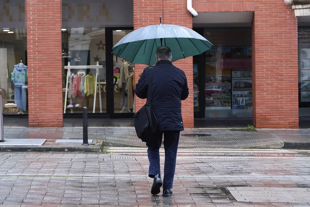 Una persona paseando con un paraguas por Santander. / C&eacute;sar Ortiz