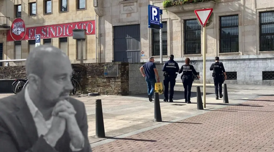 El alcalde de Torrelavega, en primer plano, observa en silencio mientras agentes de la Polic&iacute;a Local patrullan frente a la sede de UGT, epicentro del conflicto sindical que enfrenta al cuerpo policial con el sindicato y el equipo de gobierno.