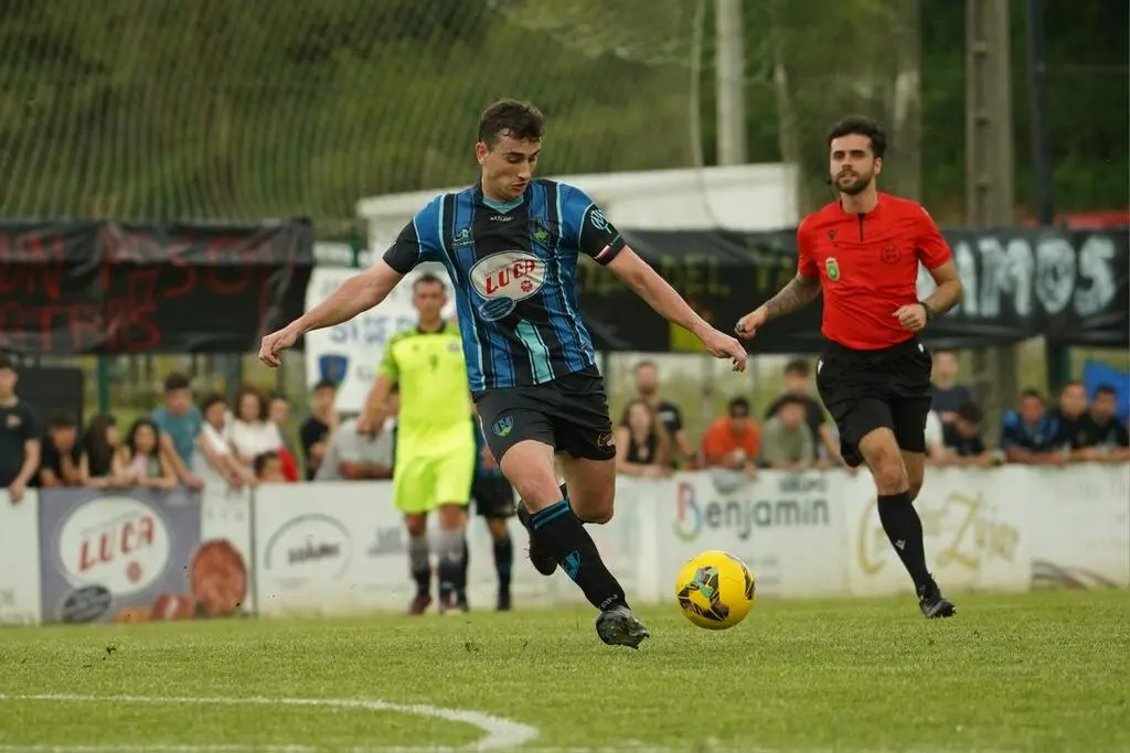 Un jugador del Monta&ntilde;as del Pas conduce el bal&oacute;n en una acci&oacute;n del partido decisivo por el ascenso a Tercera Federaci&oacute;n, bajo la atenta mirada del colegiado.
