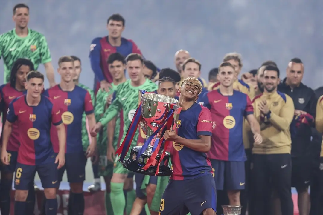Lamine Yamal levanta el trofeo de campe&oacute;n durante el &uacute;ltimo partido en Montjuic. / EP