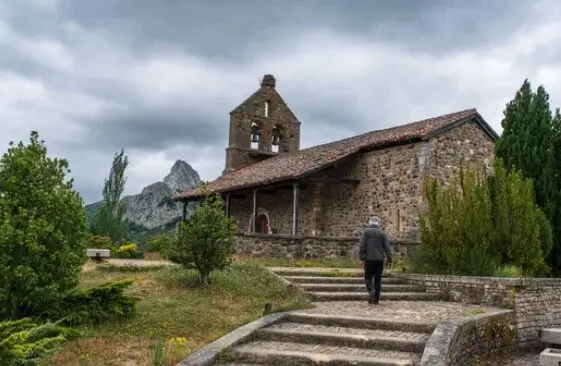 Una persona camina hacia una peque&ntilde;a iglesia en el pueblo de Ria&ntilde;o. / A.S.
