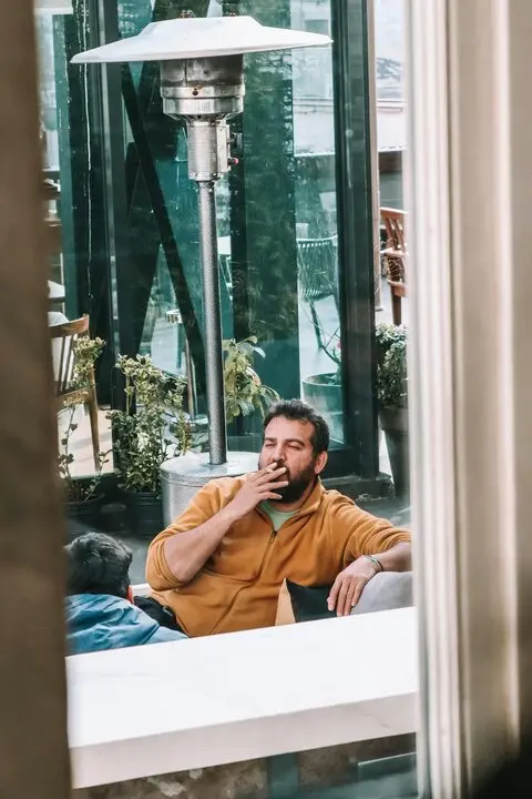 Una persona fumando en una terraza. / A.E