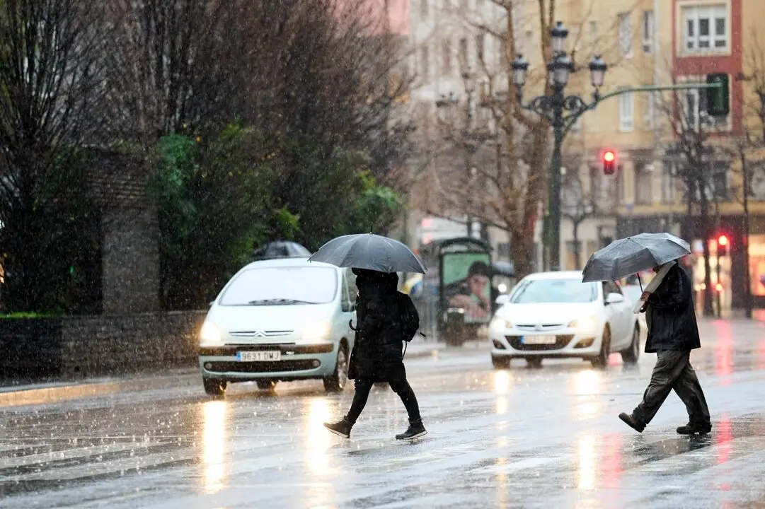 Varias personas paseando bajo la lluvia en Santander. / EP