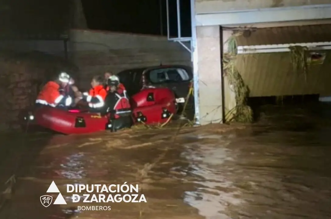 Bomberos de la Diputaci&oacute;n de Zaragoza rescatan a ciudadanos con una balsa tras las inundaciones por las fuertes lluvias en Azuara y Letux. / D.Z.