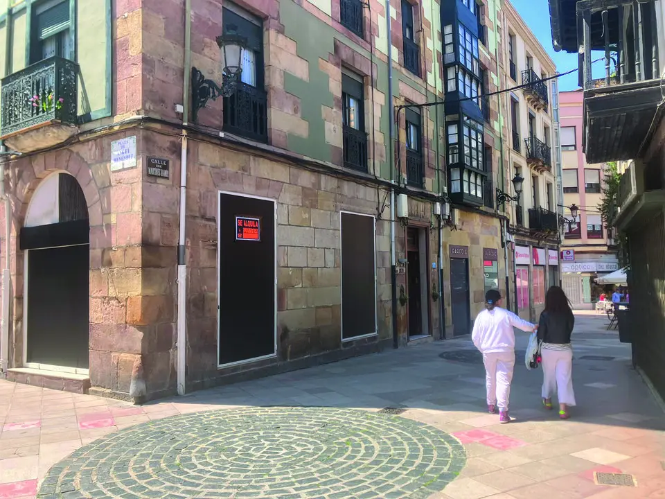 Dos personas pasean frente a un local vac&iacute;o en Torrelavega. / Alerta