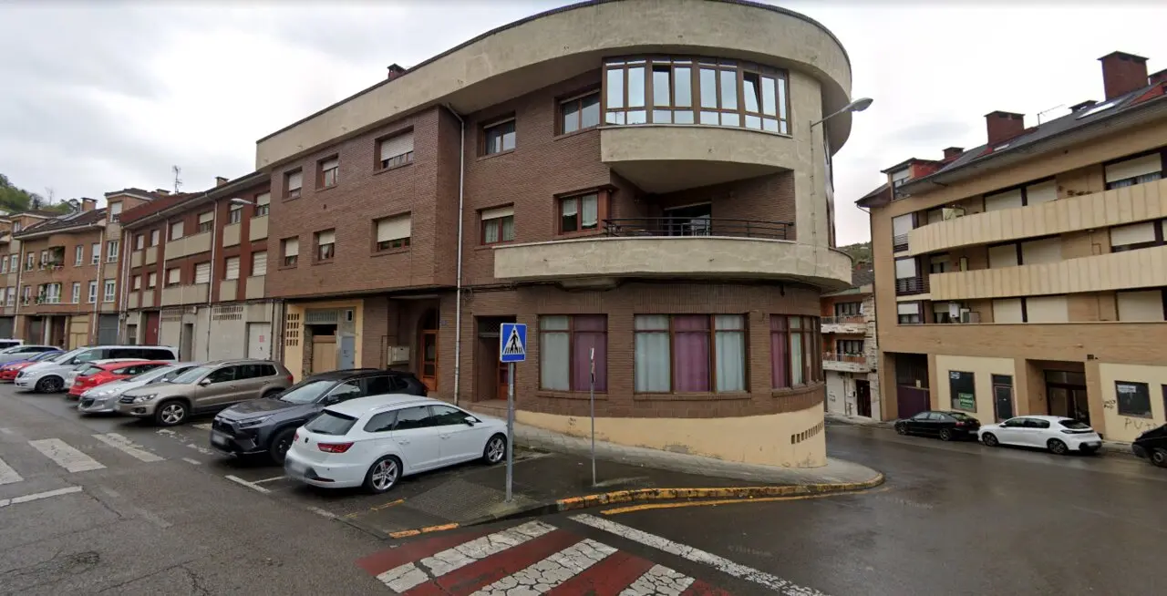 Vista del edificio de la avenida de Rioseco, en Pola de Laviana, donde esta madrugada una mujer de avanzada edad fue asesinada presuntamente por su marido. La Guardia Civil mantiene acordonada la zona mientras prosigue la investigaci&oacute;n.