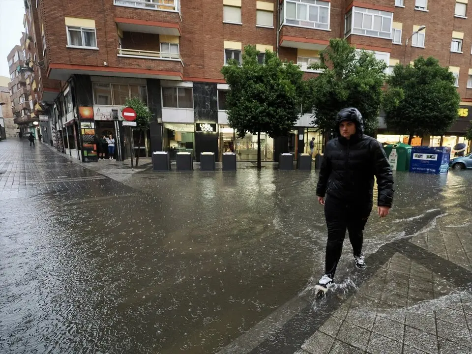 Una persona camina por una calle inundada en Valladolid. / Pablo Requejo