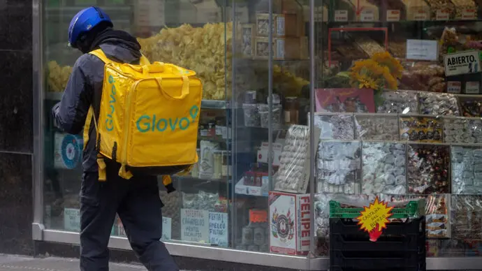 Un trabajador de Glovo delante de un escaparate. / x
