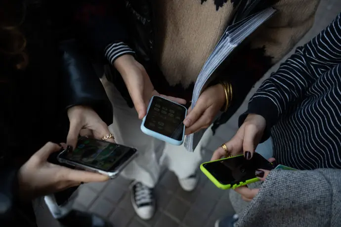 Varios ni&ntilde;os con sus m&oacute;viles en las inmediaciones del centro escolar. / EP