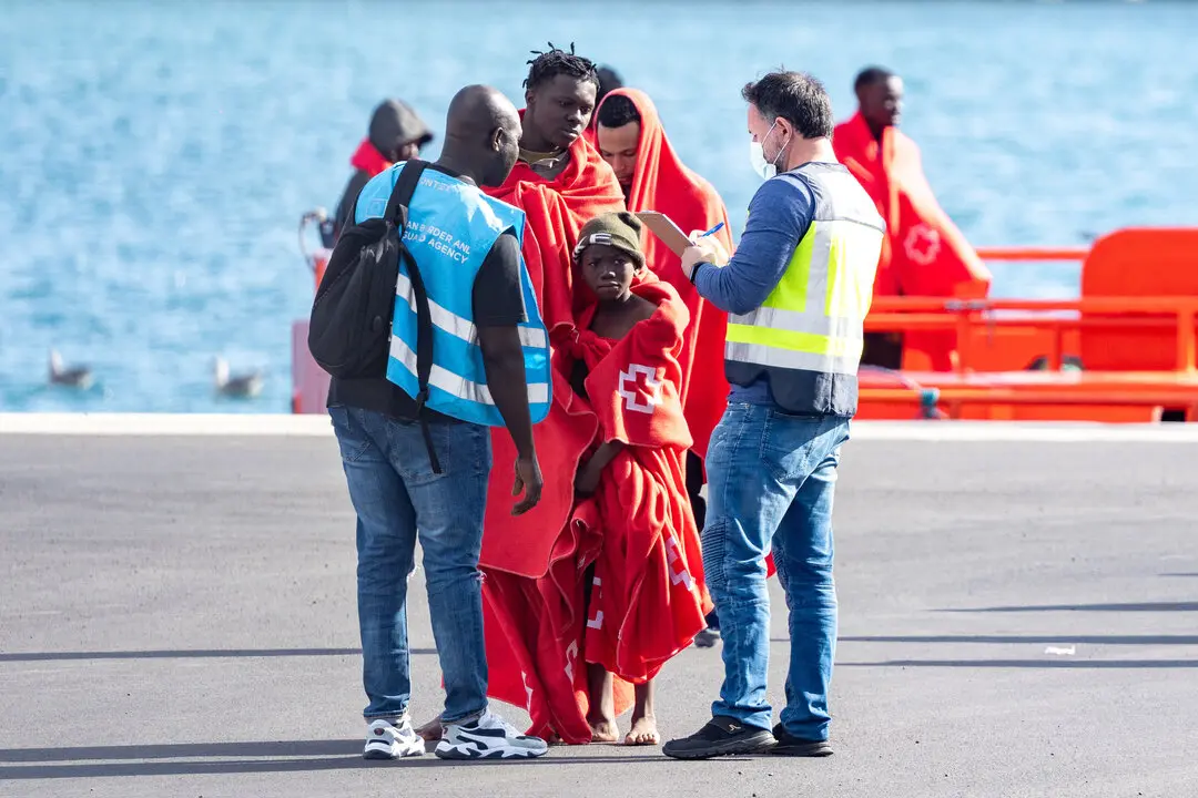 Agentes de los equipos de emergencia atienden a los migrantes en el muelle de Arrecife. / EP