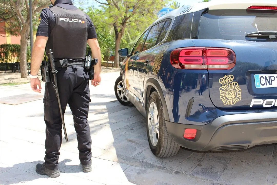 Un polic&iacute;a nacional junto a su veh&iacute;culo oficial. / EP