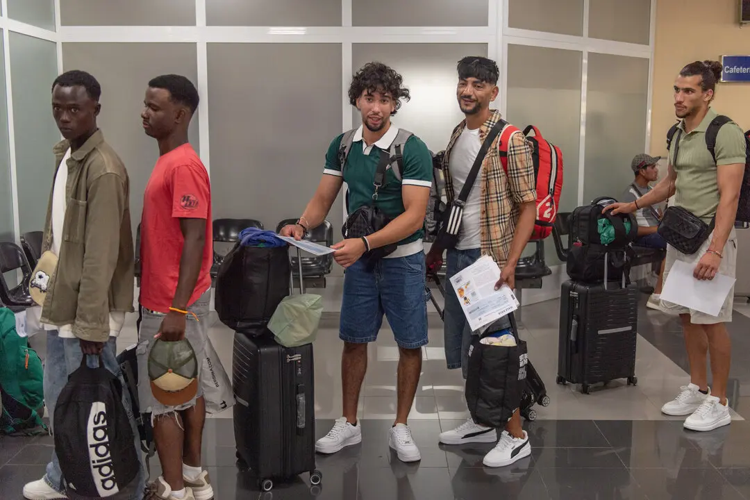 Un grupo de inmigrantes hacen cola en el Puerto de Ceuta, antes de ser trasladados a la pen&iacute;nsula. / EP