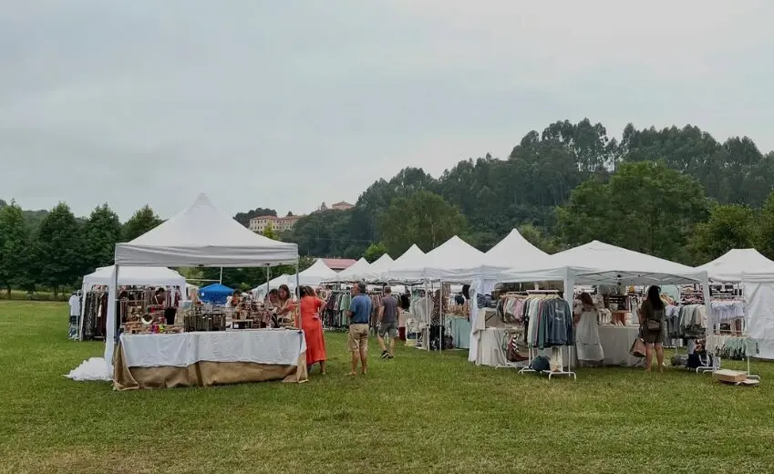 Varias personas disfrutan del mercadillo en Ruiloba. / Popupchic