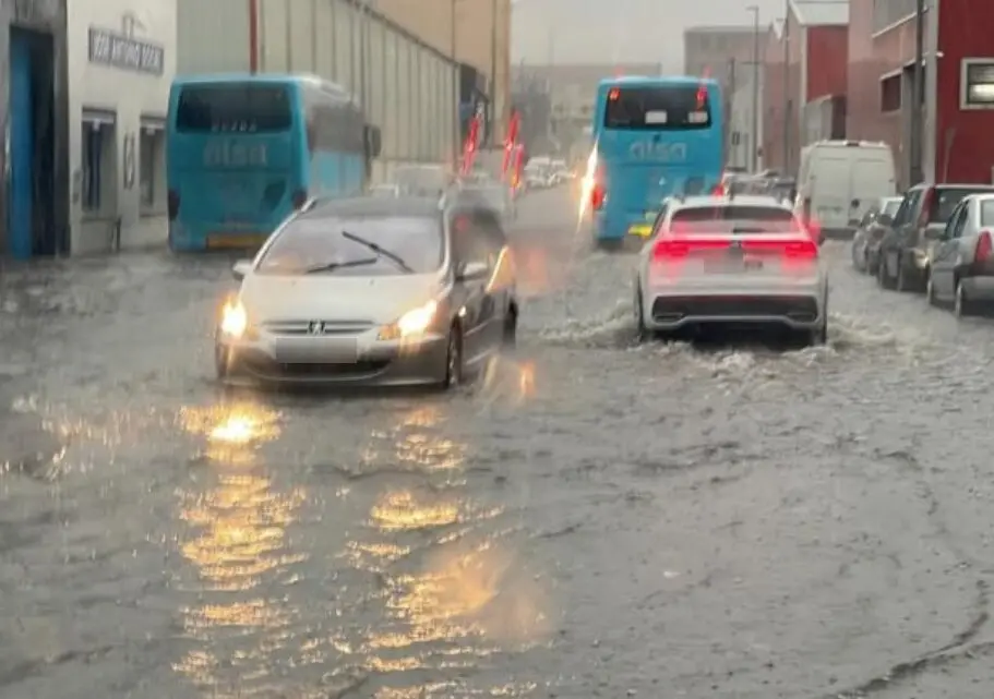 Algunos coches circulando por las calles inundadas de Santander. / x