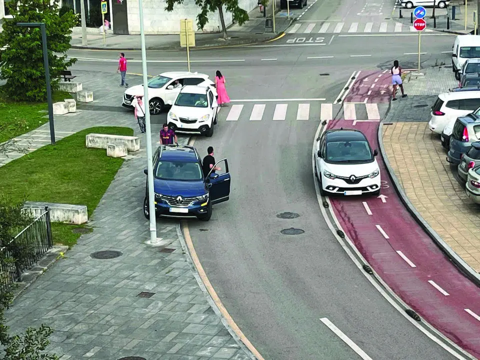 Varios veh&iacute;culos mal aparcados en una calle de Torrelavega. / A.E