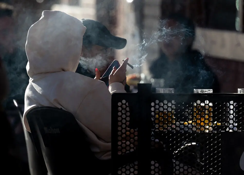 Una persona fumando en una terraza. / EP