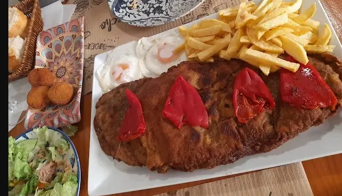 De las croquetas caseras al cachopo estrella, pasando por postres de toda la vida: este bar es una apuesta segura. / A.E