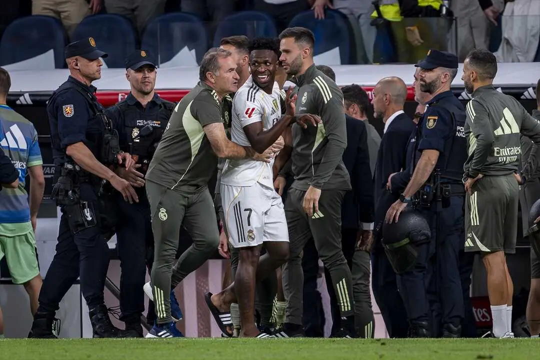 Vinicius Junior, del Real Madrid, es detenido por los asistentes del Real Madrid al final del partido de la Primera Divisi&oacute;n espa&ntilde;ola entre el Real Madrid CF y el FC Barcelona en el Estadio Santiago Bernab&eacute;u. / Alberto Gardin