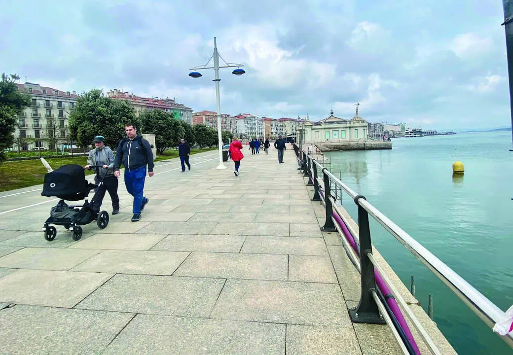 Varias personas recorren el emblem&aacute;tico paseo de la bah&iacute;a de Santander, disfrutando de las vistas y el entorno mar&iacute;timo. / Alerta