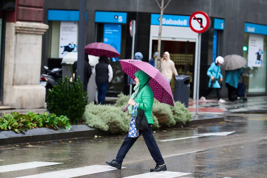 Una persona se cubre de la lluvia y el viento con paraguas. / EP