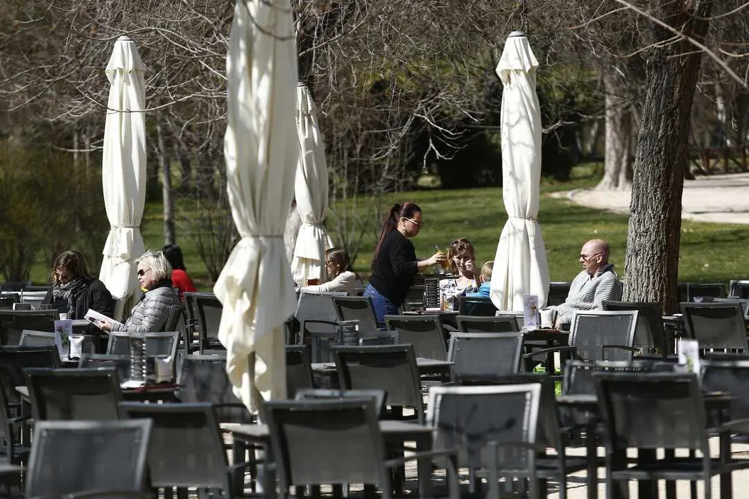 Una camarera sirve a varios clientes en una mesa de una terraza. / alerta