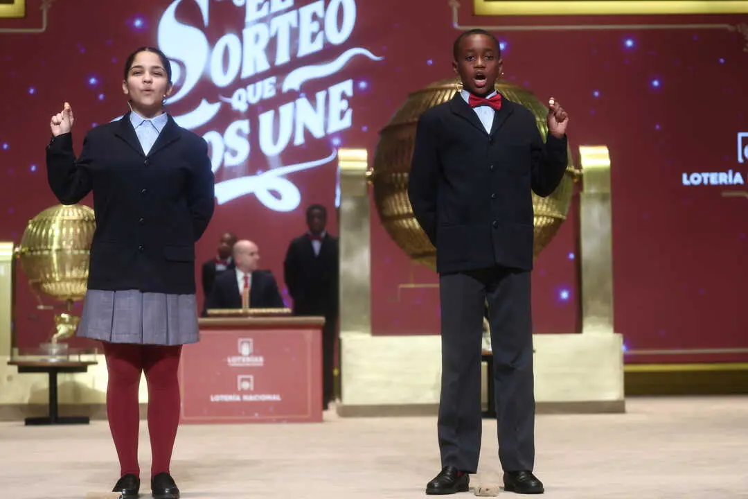 Dos ni&ntilde;os del Colegio de San Ildefonso, cantan el 70048 segundo premio de la Loter&iacute;a de Navidad. / EP