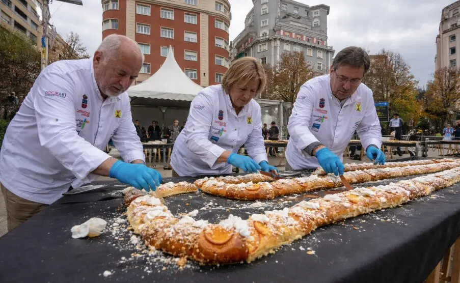 Pasteleros preparan el tradicional rosc&oacute;n solidario en la Plaza del Ayuntamiento de Santander, donde este domingo se repartir&aacute;n m&aacute;s de 1.400 raciones con chocolate a beneficio de familias vulnerables.