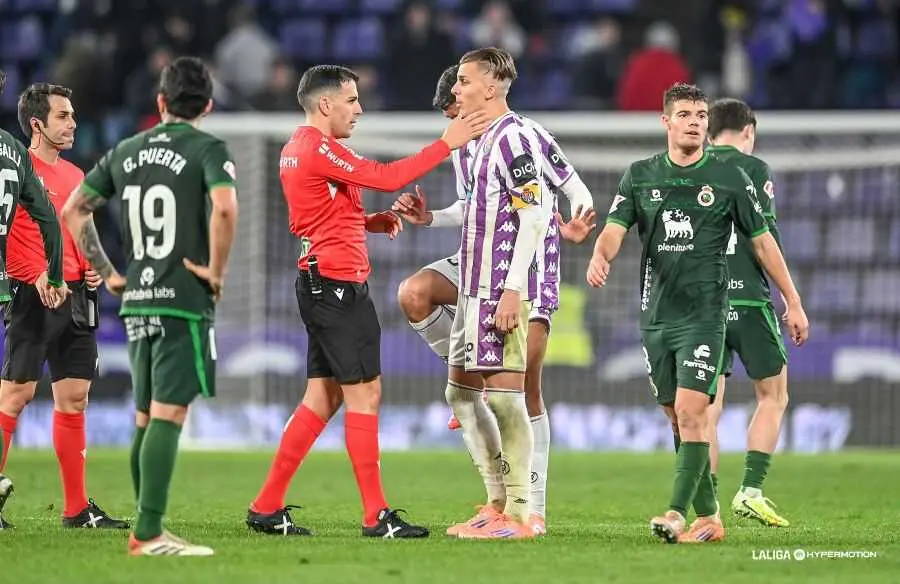 El colegiado S&aacute;nchez Villalobos dialoga con Pablo Tomeo (Real Valladolid) tras una acci&oacute;n pol&eacute;mica ante la mirada de jugadores del Racing. El partido, de alta intensidad, concluy&oacute; con empate 1-1 en Zorrilla.