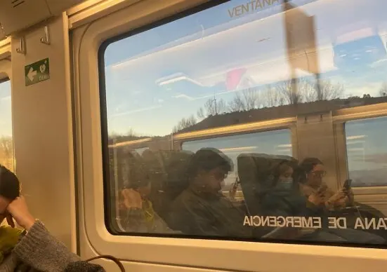 Pasajeros del Alvia Santander-Madrid, reflejados en la ventana del convoy, durante una de las m&uacute;ltiples paradas que sufri&oacute; el tren por incidencias en la infraestructura. Algunos usuarios trataron de mantenerse informados a trav&eacute;s del m&oacute;vil, mientras el ambiente oscilaba entre la resignaci&oacute;n y la tensi&oacute;n./ ALERTA