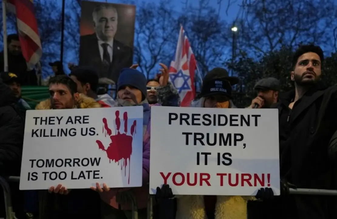 Manifestantes sostienen pancartas y banderas frente a la embajada de Ir&aacute;n en Londres, el lunes 12 de enero de 2026.