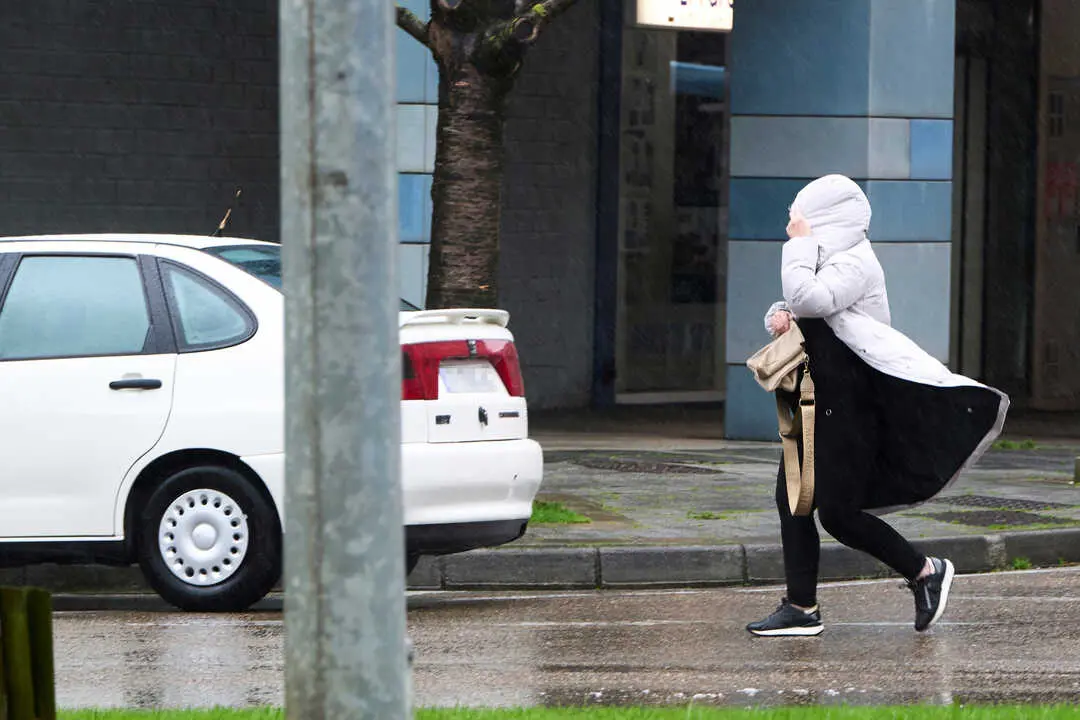 Una persona camina por una calle de Santander un d&iacute;a de viento. / EP