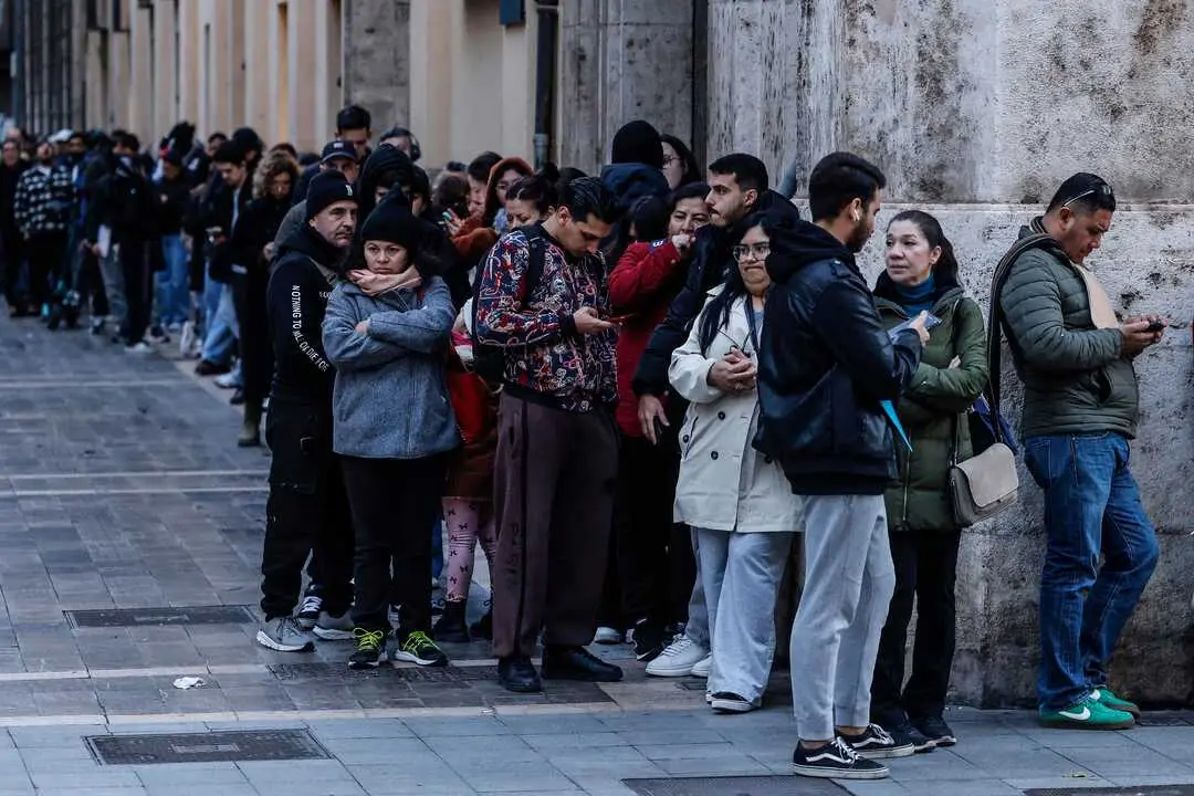 Decenas de inmigrantes hacen cola en el Ayuntamiento de Valencia. / EP