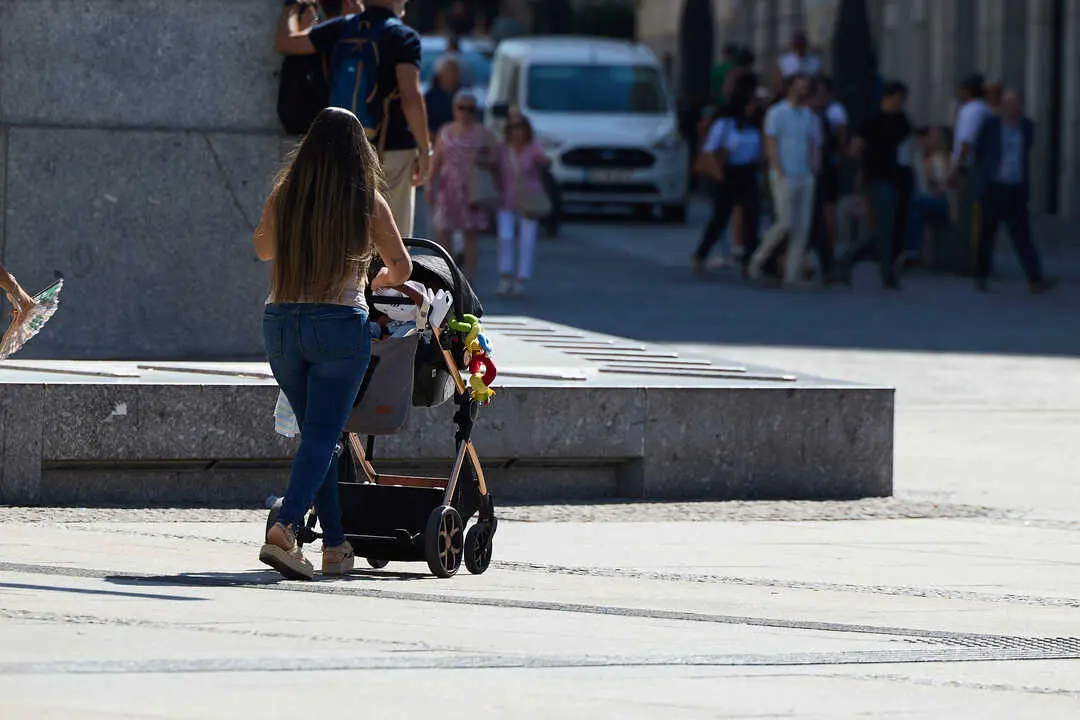 Una mujer camina por la calle con un carrito de beb&eacute;. / EP