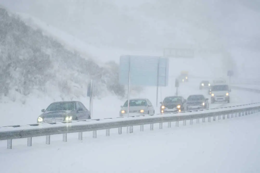 Varios coches conducen por una carretera cubierta de nieve. / EP