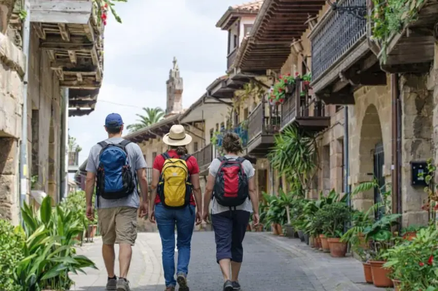 Varios turistas por la localidad de Cartes, Cantabria.