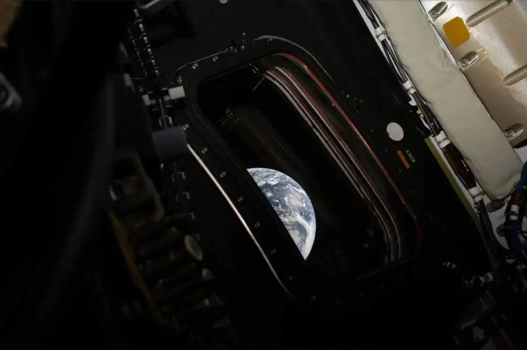 Vista de la Tierra a trav&eacute;s de la ventanilla de la c&aacute;psula Ori&oacute;n durante la misi&oacute;n Artemis II, una imagen que une tecnolog&iacute;a y fragilidad humana en el espacio profundo.