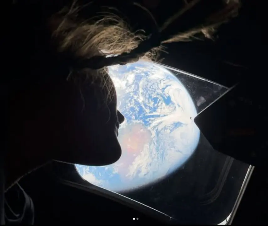 La Tierra, vista desde la ventanilla de la c&aacute;psula Ori&oacute;n, ilumina los rostros de los astronautas Christina Koch y Reid Wiseman en una imagen que simboliza el v&iacute;nculo humano con su hogar desde el espacio profundo.