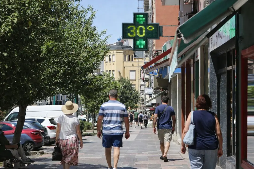 Varias personas caminan en una calle de Santander bajo el calor de primavera.